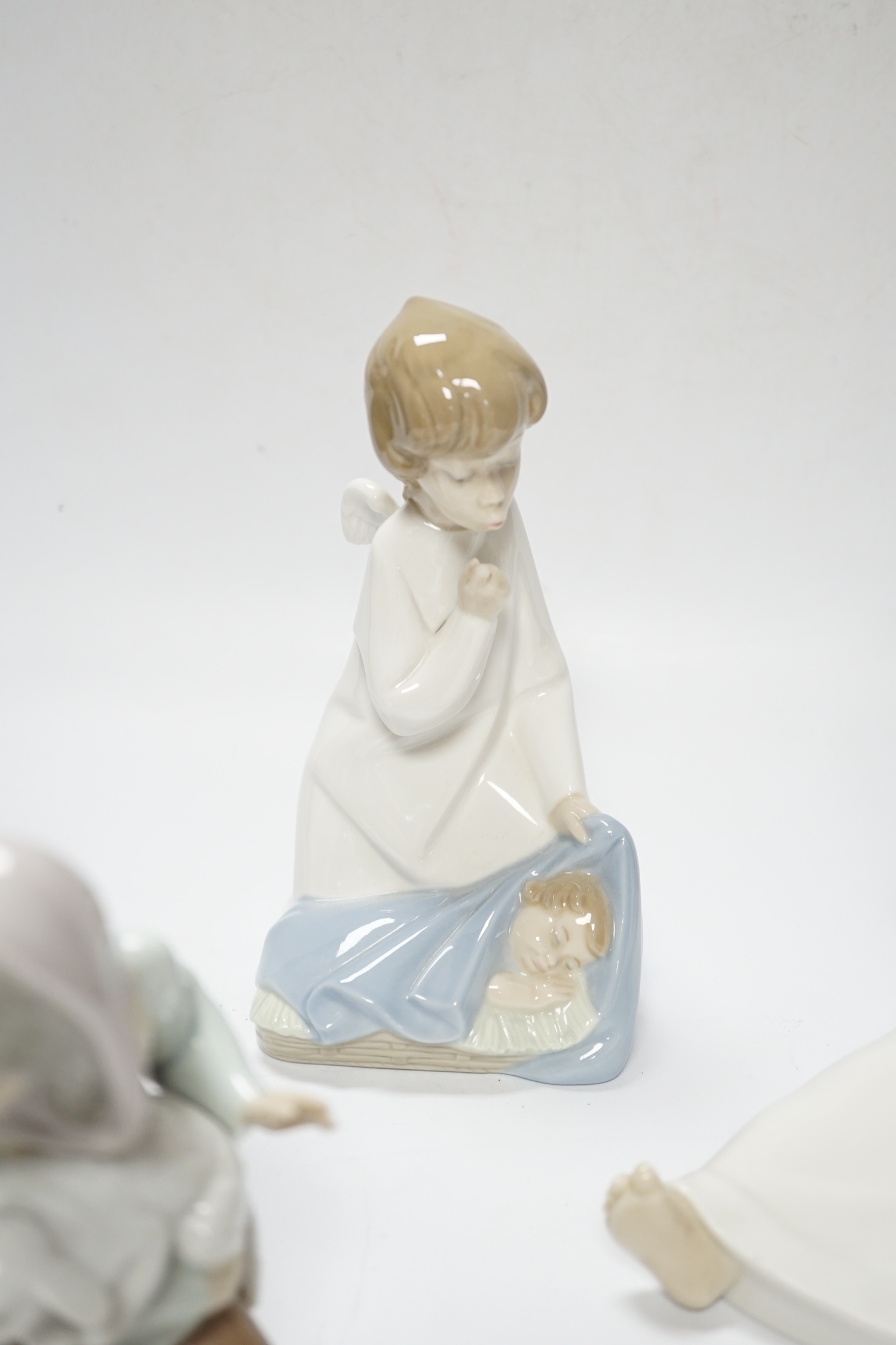 Five Lladro figures; two angelic, two nativity, one of a sleeping child and another of a girl with a lamb, all in boxed, largest 17cm high